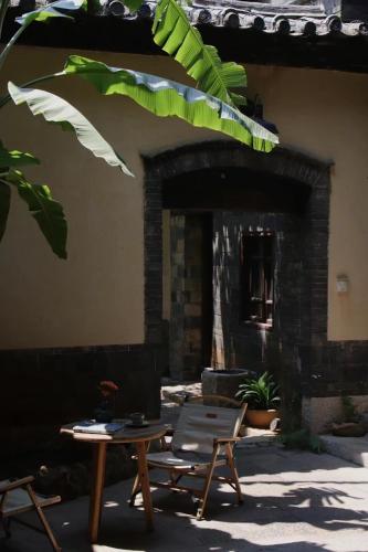 a patio with a table and a chair in front of a fireplace at Jianshui Fanqi Boutique B&B in Jianshui