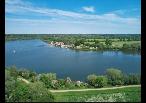 an aerial view of a large lake with trees and houses at Cambridge Apartment at St Neot in Eaton Socon