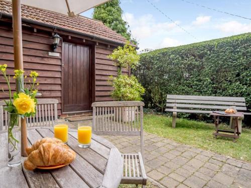 a wooden table with two glasses of orange juice at Stables Studio in Bedford