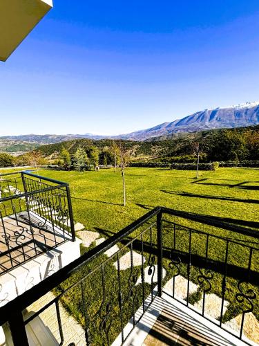 a balcony with a view of a field and mountains at Gle-Alb AgroTourism in Tepelenë