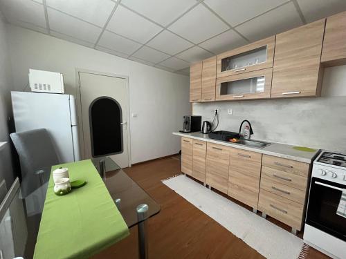 a kitchen with a green table and a refrigerator at Apartmán Majka in Snina