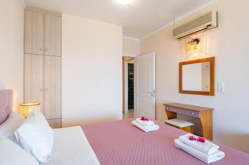 a bedroom with a bed and a desk and a mirror at Lido Sofia Apartments in Agios Gordios