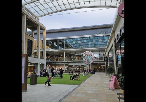 a group of people walking around a shopping mall at Cambridge Apartment at St Neot in Eaton Socon