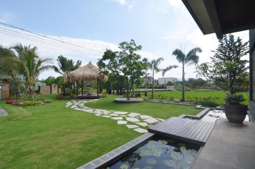 a garden with a pond and a grass yard at Full Sweet Inn in Wujie