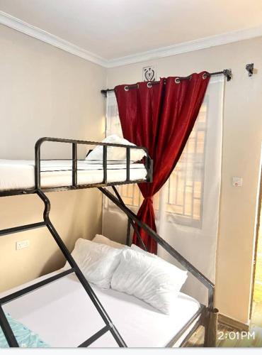 a bedroom with a bunk bed with a red curtain at Divine Homestay Arusha in Arusha