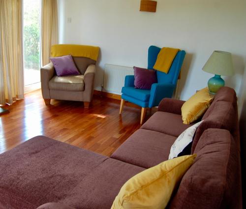 a living room with a couch and two chairs at Blue Flag Cottage in Killybegs