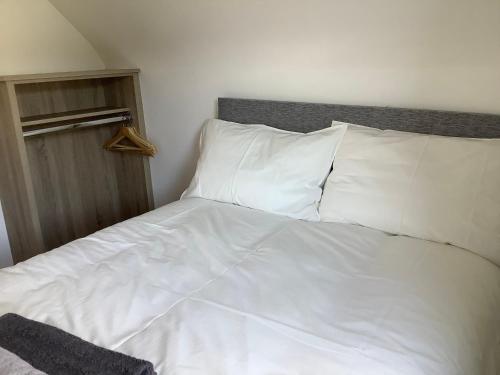 a bed with white sheets and pillows in a bedroom at Blue Flag Cottage in Killybegs