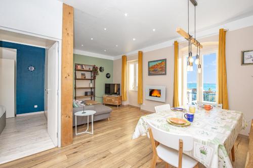 une salle à manger et un salon avec une table et des chaises dans l'établissement CONCORDIA - Agréable deux pièces - Menton Garavan - Vue Mer, à Menton