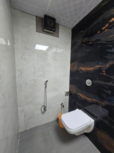a bathroom with a toilet and a shower at Hotel Fortune in Ayodhya
