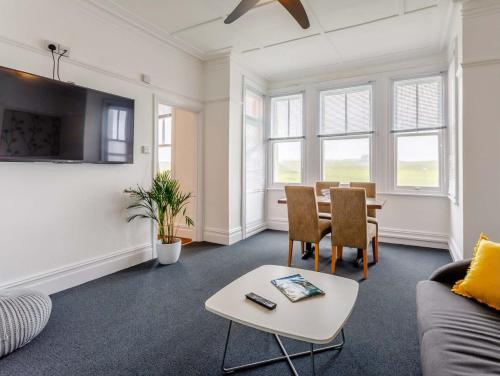a living room with a couch and a table at Tommy Jacks Beach Apartments in Bude