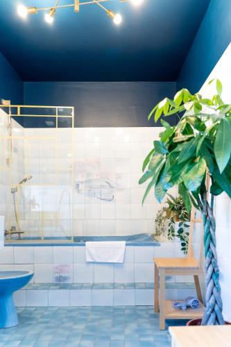 La salle de bains est pourvue de carrelage bleu et blanc. dans l'établissement Clairière des fées en Brocéliande, à Mauron