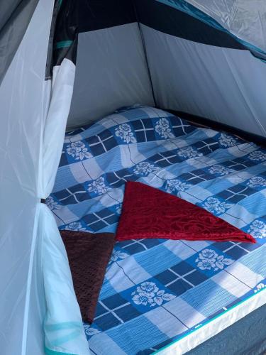 a bed in a tent with a quilt on it at Tent stay mankulam in Viripara