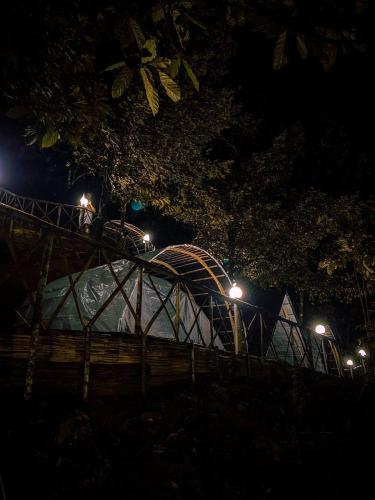 a bridge over a river at night with lights at Tent stay mankulam in Viripara