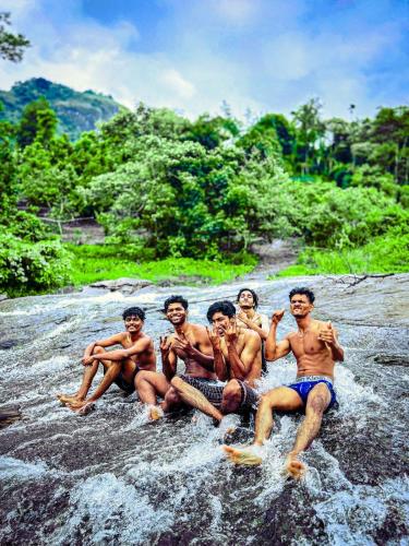 a group of men sitting in the water at Tent stay mankulam in Viripara