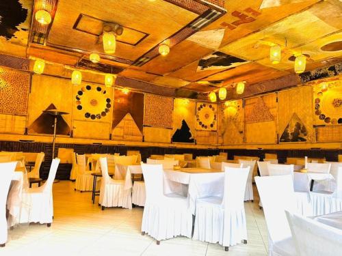 Un comedor con mesas blancas y sillas blancas. en Yohannes Guest House 22, en Addis Ababa