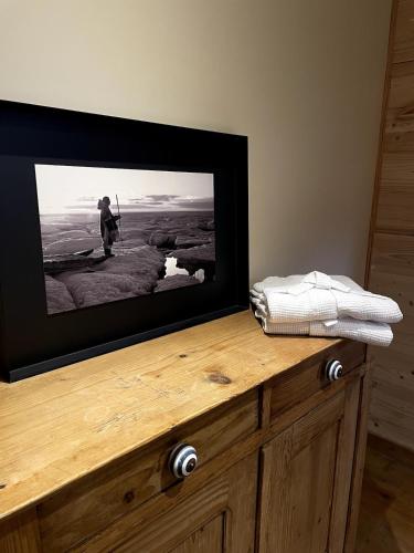 Elle comprend une télévision à écran plat installée au-dessus d'une commode en bois. dans l'établissement Chalet Nuances certifié 5 étoiles, aux Contamines-Montjoie