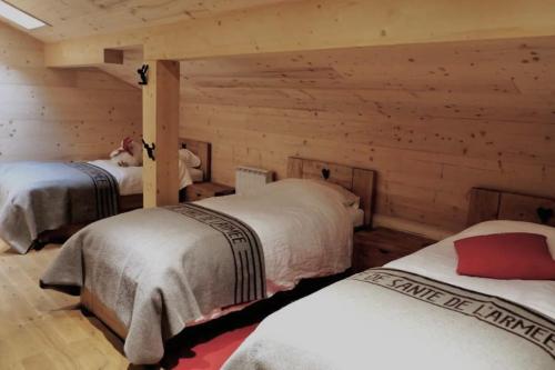 une chambre avec deux lits dans une cabane en rondins dans l'établissement Chalet Nuances certifié 5 étoiles, aux Contamines-Montjoie