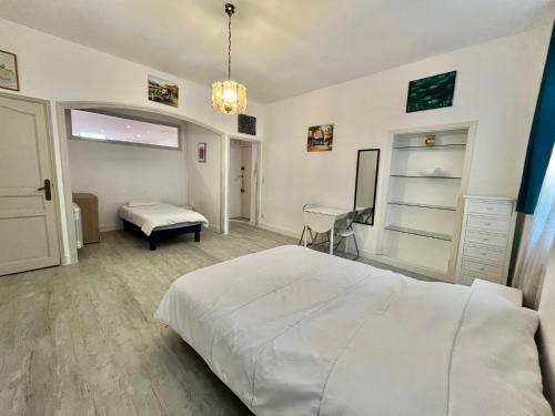 une chambre avec un grand lit blanc et un bureau dans l'établissement Honore apartment 3 min from Palais des Festivals by Welcome to Cannes, à Cannes