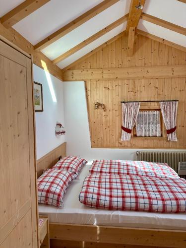 a bedroom with a red and white plaid bed at Scurcia in Ortisei