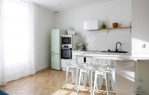 La cuisine est équipée d'un réfrigérateur vert et de tabourets blancs. dans l'établissement La Terrasse du Canigou - App 1-1 - Town centre, à Perpignan