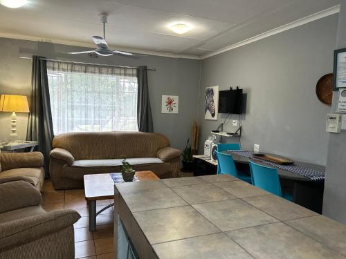 a living room with a couch and a table at Sabie Self Catering Apartments in Sabie