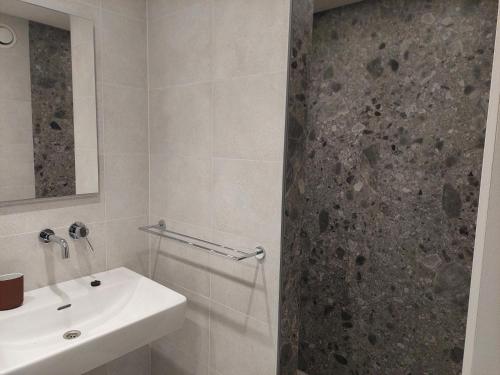 TieltにあるKrie1の洗面台とシャワー付きの白いバスルーム