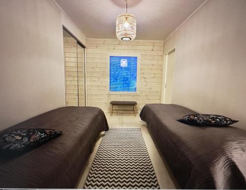a small room with two beds and a window at Kiiruna Chalet in Kuusamo