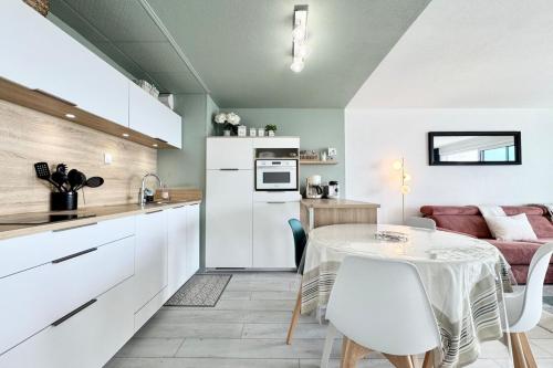 a kitchen and dining room with a table and chairs at Somptueux appartement - vue imprenable sur l'océan in Guidel