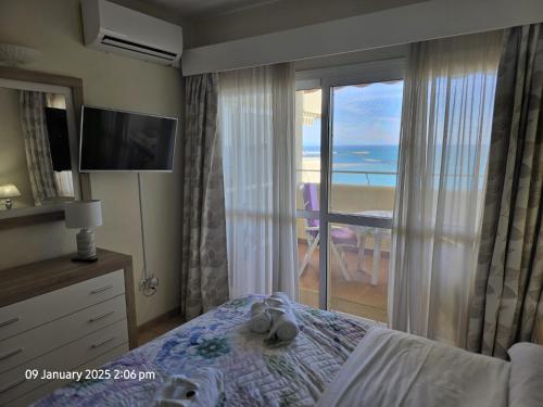 a bedroom with a bed and a view of the ocean at Benal Beach Apartments in Málaga