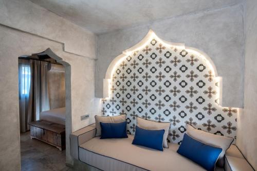 a room with a couch with blue pillows and a wall at DECAN Concept Boutique Estate in Rhodes Town