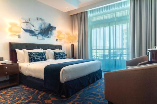 ドバイにあるMD Hotel By Gewanのベッドと大きな窓があるホテルの部屋
