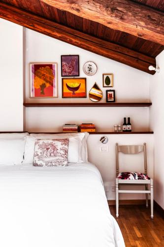 a bedroom with a white bed and a chair at Ca' De Memi in Piombino Dese