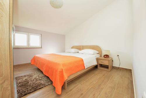 a bedroom with a bed with an orange blanket at Villa Zvizda in Zadar