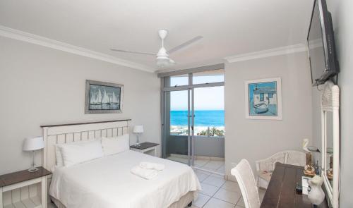 a bedroom with a bed and a view of the ocean at 53 Sea Lodge Umhlanga Rocks in Durban
