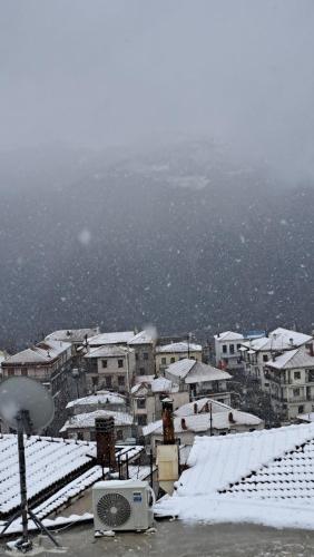 a city covered in snow with buildings in the background at Ξενώνας Ονειροπαγίδα in Arachova