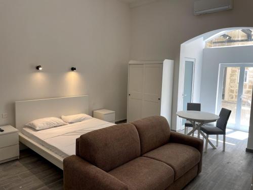 a bedroom with a bed and a table with chairs at The Old Mint House sleeps 15 in Valletta