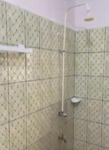 ein Badezimmer mit Dusche und gefliester Wand in der Unterkunft 77 Shortlets in Cotonou