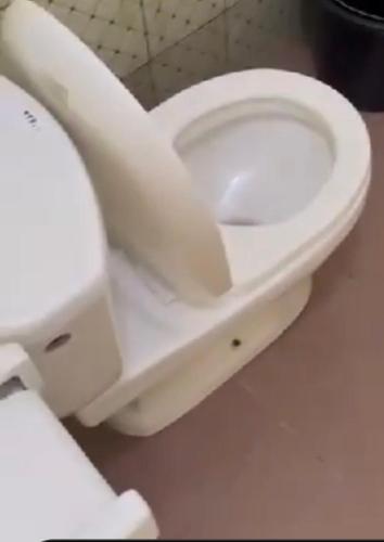 eine weiße Toilette in einem Badezimmer mit geöffnetem Deckel in der Unterkunft 77 Shortlets in Cotonou