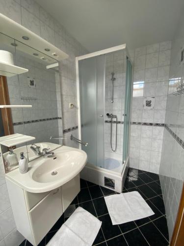 a white bathroom with a sink and a shower at Guesthouse Magdalena in Rakovica