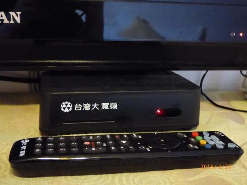 a computer monitor with a keyboard and a remote control at Flower Bird House B&B in Jiaoxi