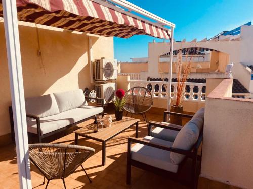 a patio with a couch and tables on a balcony at Casa hollandia in Torrevieja