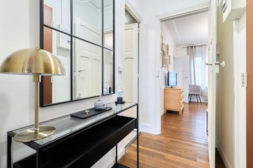 Cette chambre comprend une table avec une lampe et un miroir. dans l'établissement Suite Vesle, à Reims