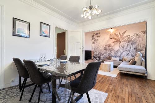 une salle à manger avec une table, des chaises et un canapé dans l'établissement Suite Vesle, à Reims