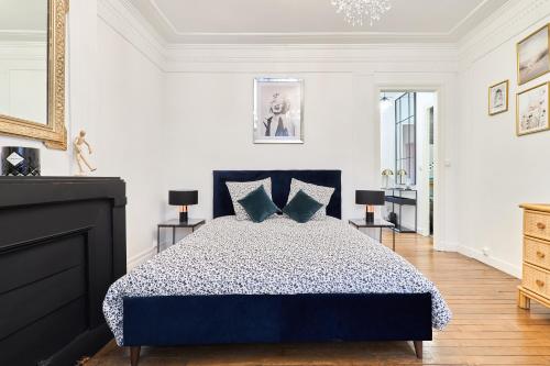 une chambre avec un grand lit avec des oreillers bleus dans l'établissement Suite Vesle, à Reims