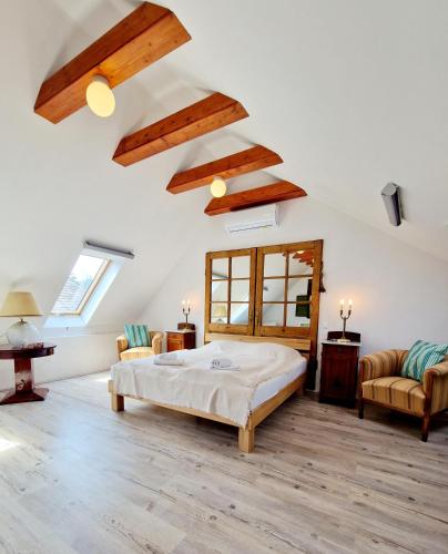 a bedroom with a bed and two chairs at Káli Cool in Káptalantóti
