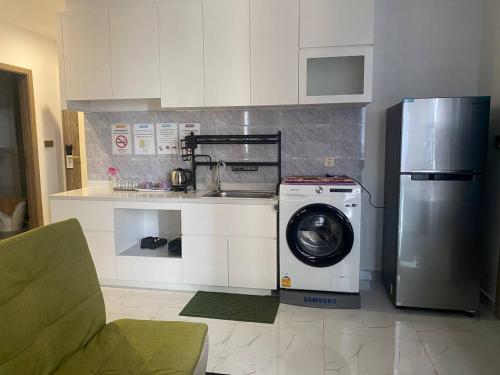 a kitchen with a washing machine and a refrigerator at The Vincent Apartment in Phnom Penh