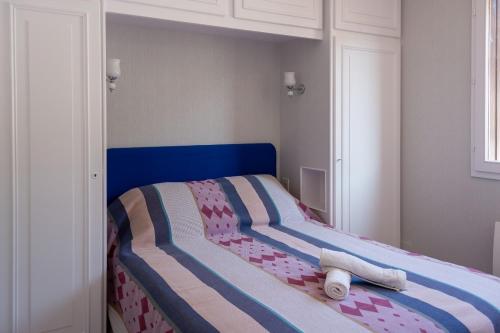 un letto con testiera blu in una camera da letto di Les Reflets de la Houle a Cancale