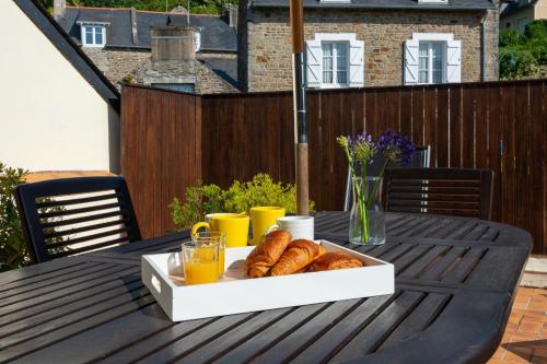 een tafel met croissants en jus d'orange bij Les Reflets de la Houle in Cancale