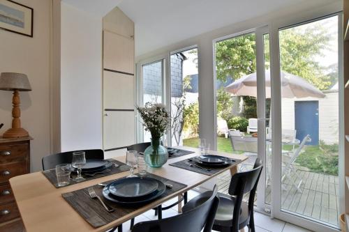 - une salle à manger avec une table en bois, des chaises et une table dans l'établissement Maison de charme dans rue très calme, à Saint-Malo