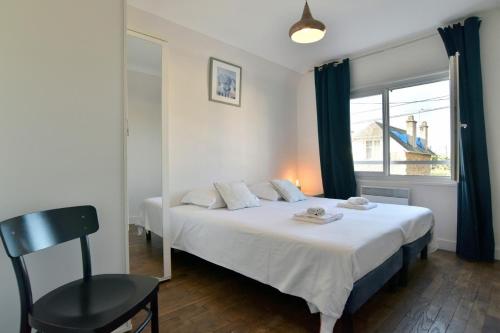 - une chambre avec un lit, une fenêtre et une chaise dans l'établissement Maison de charme dans rue très calme, à Saint-Malo
